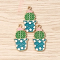 Macro detail of three cactus alloy charms with pink flowers and blue polka dot pots - Green