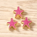 Dettaglio di tre ciondoli a forma di stella marina in smalto rosa con bordo dorato - 10 Pezzi/Confezione / Rosso rosa