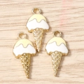 Makroaufnahme von drei vergoldeten Eiscreme-Emaille-Anhängern für DIY-Schmuck - Eiscremeform / Gelb