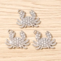 Detalle macro de colgantes de cangrejo con diamantes de imitación para joyería DIY - Plateado