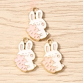 Detailed view of three white rabbit enamel charms with pink carrots for DIY jewelry making - Pink