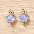 Détail de pendentifs chat doré et étoile arc-en-ciel sur fond en bois naturel - Violet Or