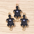 Detail of three golden turtle charms with black enamel and evil eye motif on wood - 10 Pieces Pack / Black