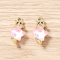 Vue détaillée de deux têtes de chat dorées avec pendentifs étoiles roses sur bois - Or Rose