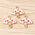 Vue détaillée de trois pendentifs éventails émaillés avec fleurs pour création bijoux - Lot de 10 / Blanc