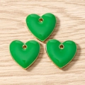 Macro detail of three green heart enamel charms with gold plating for DIY jewelry - Green