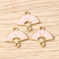 Detailed macro view of pink enamel fan-shaped charms with white plum blossom patterns for DIY - 10 Pieces Pack / Pink