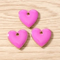 Detail view of pink enamel heart pendants with gold metal edges on a light wood background - Rose Red