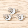 Macro detail of three silver star and moon pendants for DIY jewelry making on wood - Silver Blue