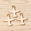 Vista macro de tres colgantes de avión en esmalte crema y dorado sobre madera - Paquete de 10 / Rosa