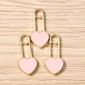 Vista dettagliata dei ciondoli a cuore in smalto rosa con clip in metallo dorato su legno - Confezione da 10 / Rosa