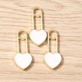 Dettaglio macro di tre ciondoli a forma di lucchetto a cuore dorati con smalto bianco - Confezione da 10 / Bianco
