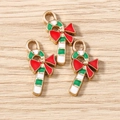 Macro detail of three enamel Christmas candy cane charms with festive red bows - Candy Cane Shape / 10 Pieces Pack