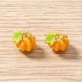 Close-up of small orange pumpkin pendants with green leaves and gold plated metal loops - 5 Pieces / Yellow