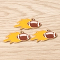 Drei Rugby-Anhänger mit gelben Flammen-Details auf hellem Holzuntergrund - 10er Pack / Feuer Football