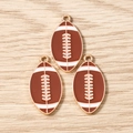 Drei Rugbyball-Anhänger mit brauner Emaille und goldenen Metallhaken in Nahaufnahme - 10er Pack / Basis Football