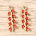 Détail macro de pendentifs pétard rouge avec cadre en métal doré et finition émail - Lot de 10 / Pétard Or Clair
