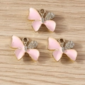 Detailansicht handgefertigter Emaille-Schmetterling-Anhänger mit glitzernden Strasssteinen - Gold Rosa
