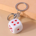 Dettaglio di un portachiavi a dado bianco con cuori rossi su espositore moderno - Bianco