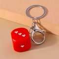 Dettaglio del portachiavi a dado rosso con punti a forma di cuore bianco e moschettone - Rosso