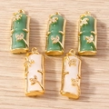 Dettaglio di ciondoli a forma di bambù in finta giada verde e bianca con foglie d'oro - Multicolore
