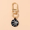 Détail d'un porte-clés basket doré avec finition en émail noir et fermoir mousqueton - Noir & Blanc