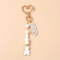 Detail of golden heart clasp with beaded chain and sparkling rhinestone heart charms - White