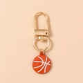 Vue détaillée d'un porte-clés basket-ball orange avec fermoir doré et lignes blanches - Marron et Blanc