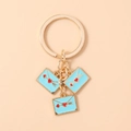 Close-up of three blue enamel heart envelope pendants on a gold keychain ring - Blue