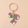 Dettaglio portachiavi dorato a cuore e pezzo di puzzle con smalto colorato vivace - Puzzle Geometrico Viola Rosa Verde