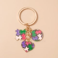 Dettaglio del portachiavi puzzle a cuore geometrico con smalto colorato e anello dorato - Puzzle a Cuore Viola Rosa Verde