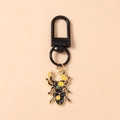 Dettaglio del portachiavi a scarabeo nero con motivo floreale giallo e gancio a D in metallo - Coccinella