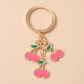 Detailed view of pink enamel cherry charms with gold metal edges on a stylish keychain - Rose Red