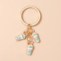 Detail of three blue milk tea charms with pink hearts on a gold-plated metal keychain - Pink Heart Milk Tea