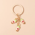 Detail view of heart-patterned bubble tea enamel pendants on a gold keychain - Skin Color Milk Tea