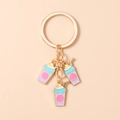 Close-up of golden metal keychain featuring colorful enamel coffee cup pendants - Purple Milk Tea