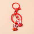Detailaufnahme roter Schlüsselanhänger mit Hasen-Obst-Motiven und Karabinerverschluss - Rot