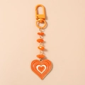 Detail of beaded heart keychain with orange resin beads and heart-shaped pendant charms - Orange