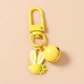 Close-up of yellow strawberry rabbit charm with metal lobster clasp and bell pendant - Yellow