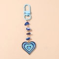 Close-up of heart enamel pendant with turquoise stones and blue beaded keychain - Blue