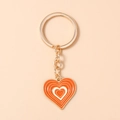 Detail van oranje en witte hartvormige sleutelhanger met vergulde metalen schakel - Oranje