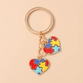 Détail de pendentifs cœur en puzzle émaillé coloré sur un porte-clés doré brillant - Style de Puzzle en Cœur Coloré