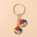 Gros plan du porte-clés doré avec pendentifs cœur puzzle colorés et finition en émail - Style de Puzzle Rond Coloré