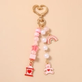 Detailed view of pink bear beaded keychain with gold heart clasp and rainbow charms - Bear Rainbow
