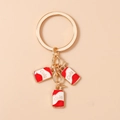 Detailed macro view of three gold alloy mini soda can pendants with red cola engraving - White