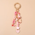 Dettaglio del portachiavi di perle rosa con ciondolo LOVE e cuore Merry Me - Stella Cuore