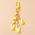 Detail view of yellow strawberry rabbit pendants with star beads on metal alloy keychain - Yellow Strawberry Rabbit