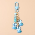 Detail of blue strawberry rabbit charms on a keychain with metallic blue hook - Blue Strawberry Rabbit