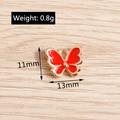 Dettaglio macro del ciondolo a farfalla in smalto rosso 11x13mm con specifica di peso 0.8g - Smalto Rosso (YD005hongse)
