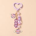 Dettaglio portachiavi a cuore viola con ciondoli a pianeta e perline di cristallo lucide - Viola